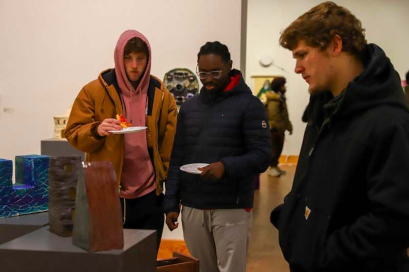 a group of people standing around a sculpture