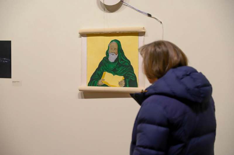 a woman looking at a painting on a wall