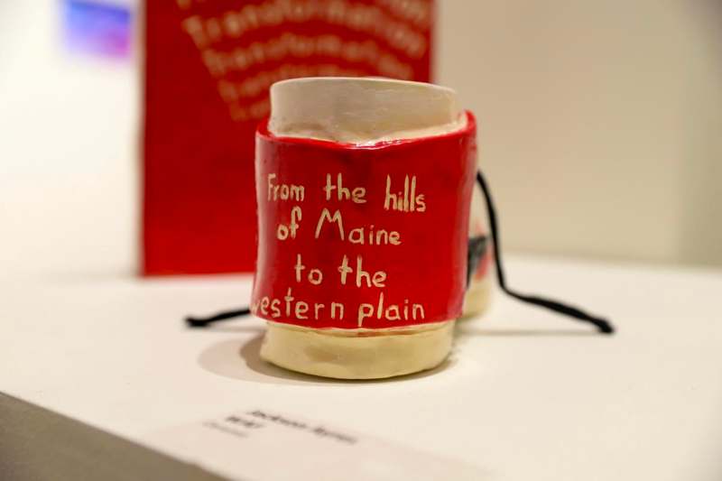 a red and white ceramic object with writing on it