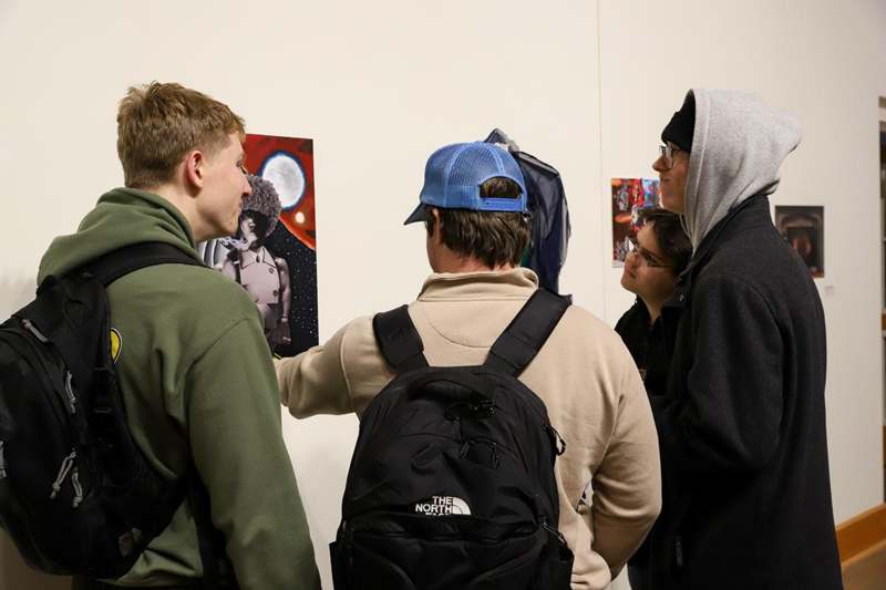 a group of people looking at a painting