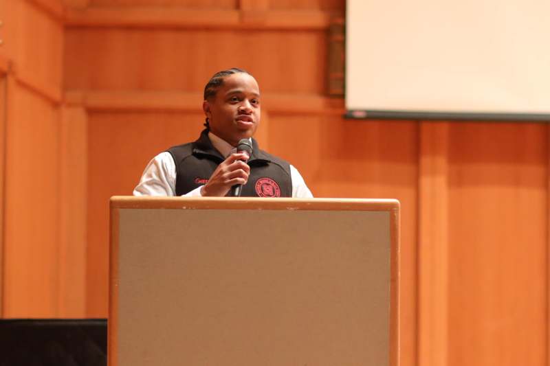 a man standing at a podium with a microphone