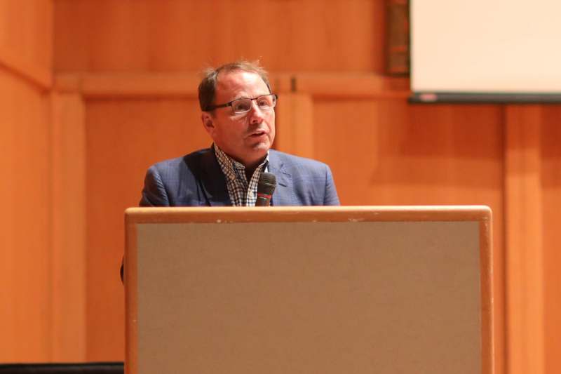a man in a suit speaking into a microphone