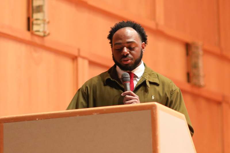 a man standing at a podium holding a microphone