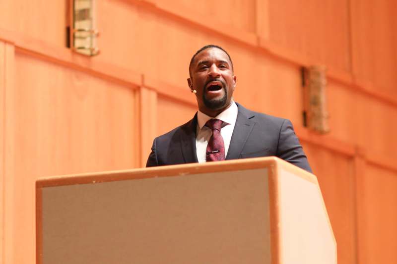 a man in a suit speaking at a podium