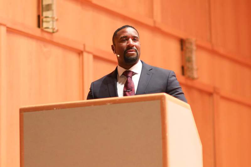 a man in a suit and tie standing at a podium