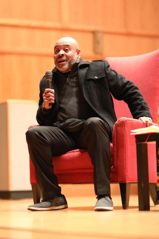 a man sitting in a chair holding a microphone