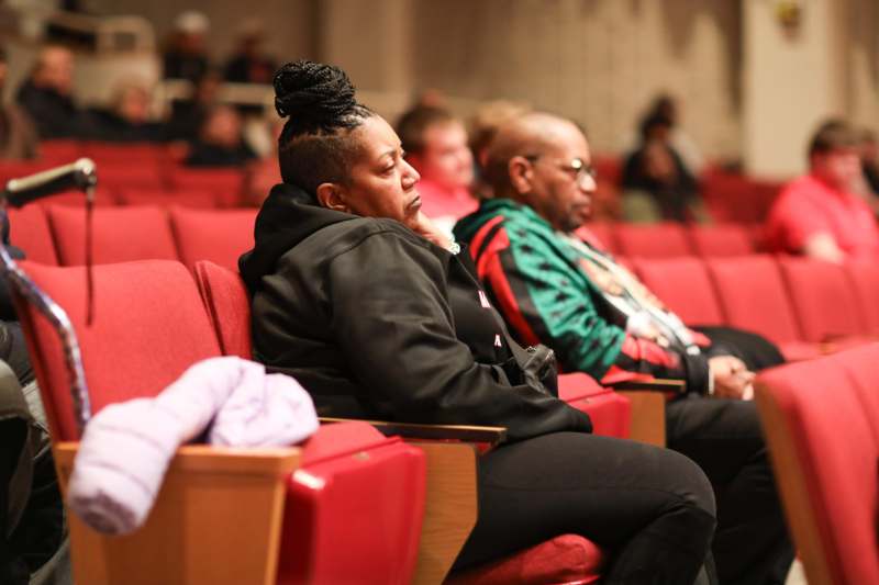 a group of people sitting in red seats