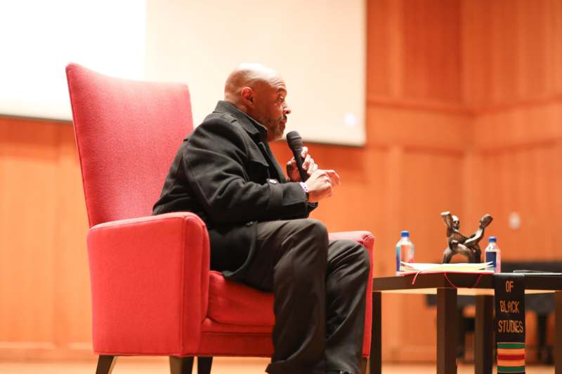 a man sitting in a red chair holding a microphone