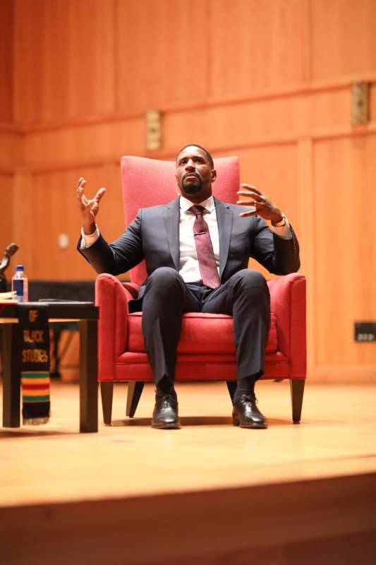 a man in a suit sitting in a red chair