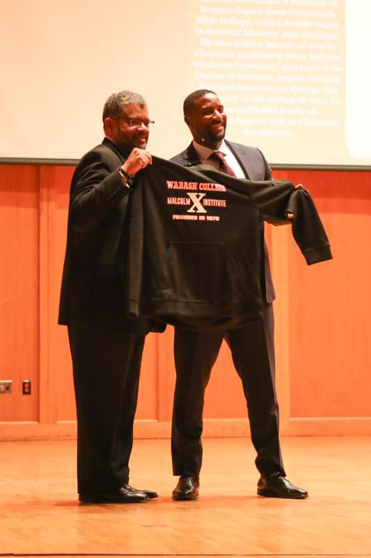 two men holding up a sweatshirt