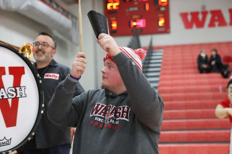 a man holding a bell and a drum