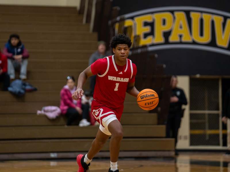 a man in a red uniform dribbling a basketball