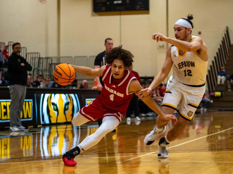 a basketball player in a red uniform running with a basketball in the air