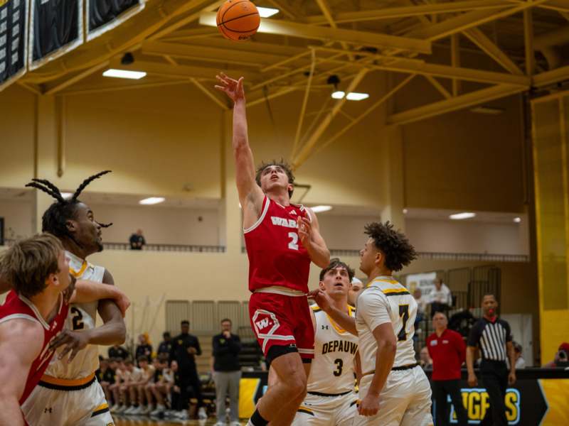 a basketball player in a red uniform jumping to block a basketball