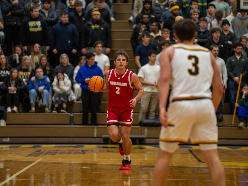 a basketball player running with a ball in front of a crowd