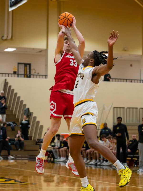 a basketball player in a red uniform jumping to block a basketball
