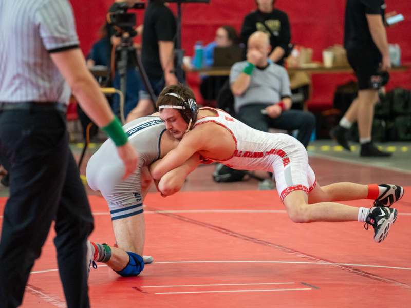 a two men wrestling on a mat