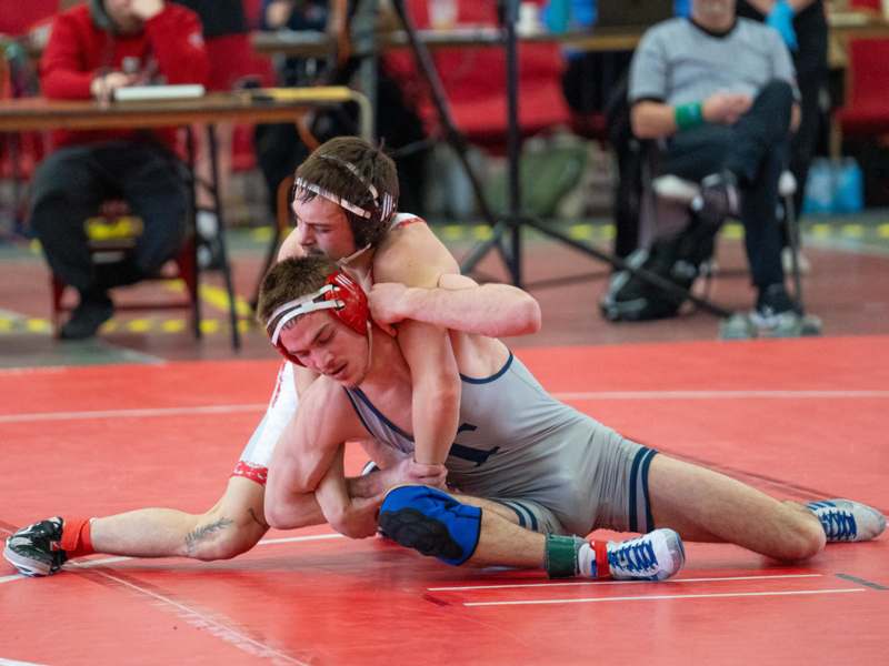 a man wrestling on a red mat