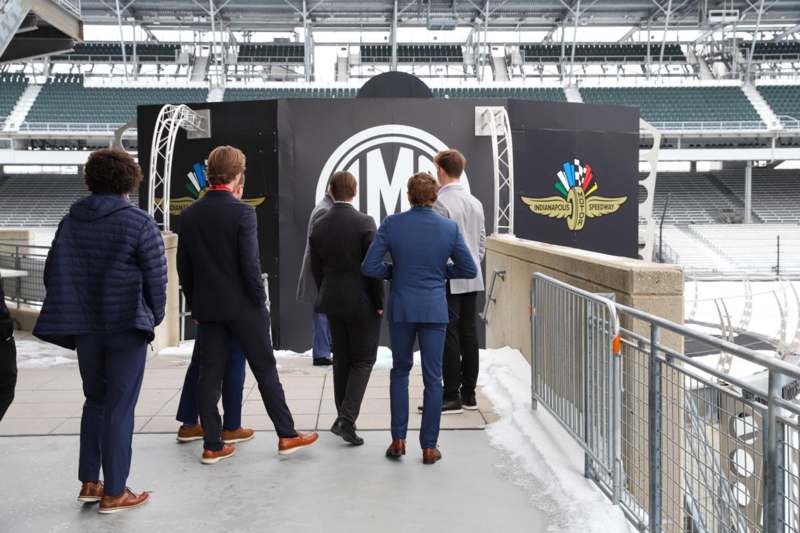 a group of people standing in front of a black sign
