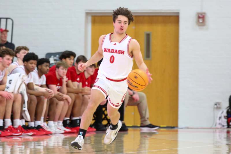 a man in a basketball uniform running with a basketball