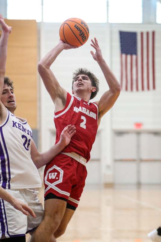 a basketball player in red uniform with a basketball in the air