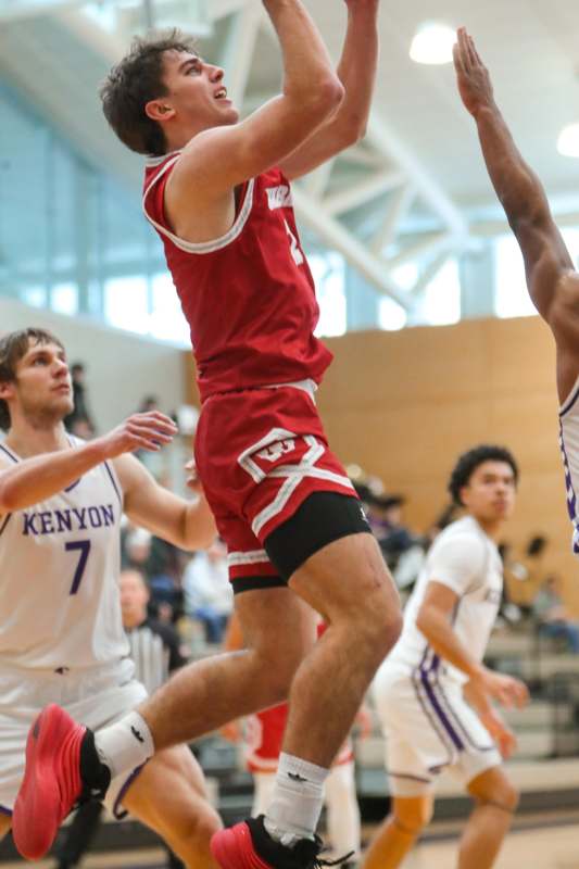 a man in a red uniform jumping to dunk a basketball