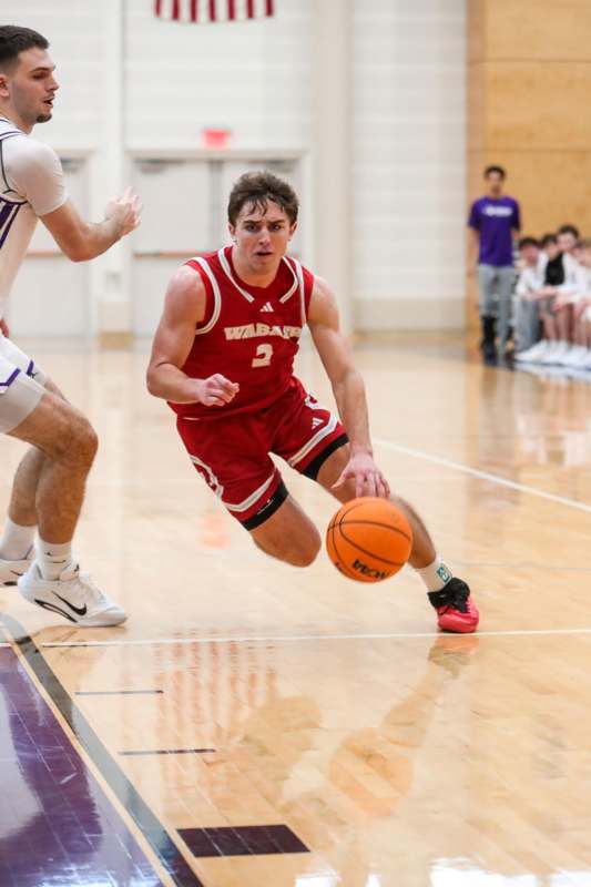 a man in a red uniform running with a basketball
