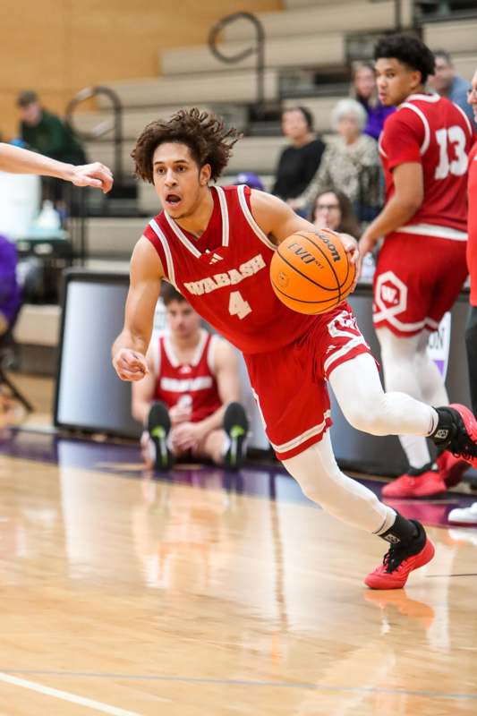 a man in a red uniform running with a basketball