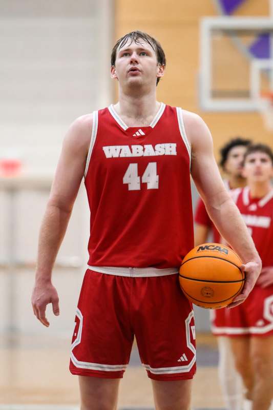 a man in a basketball uniform holding a basketball