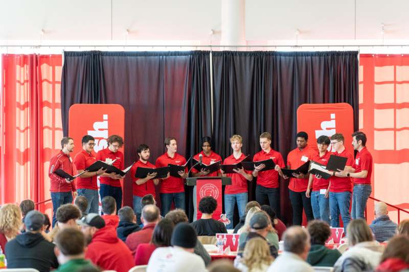 a group of people singing in front of a crowd