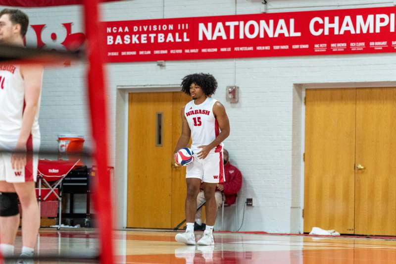 a man holding a ball in a gym