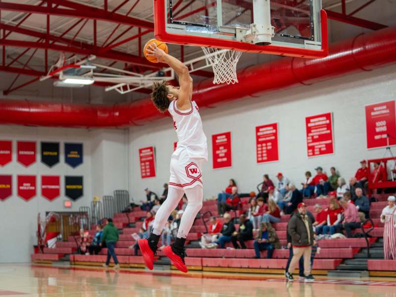 a basketball player in mid air in a gym