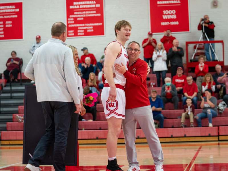 a man hugging a basketball player