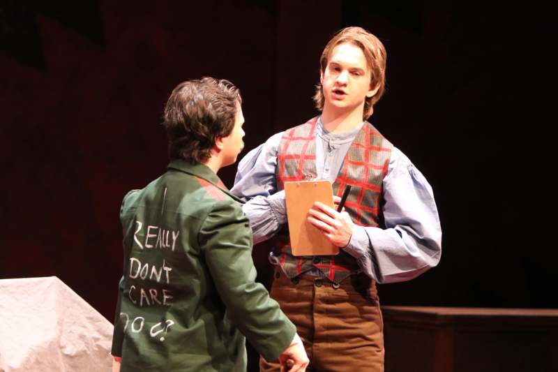 a man holding a clipboard and talking to another man