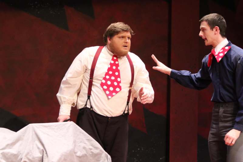 a man in a white shirt and red tie standing next to a man in a red shirt