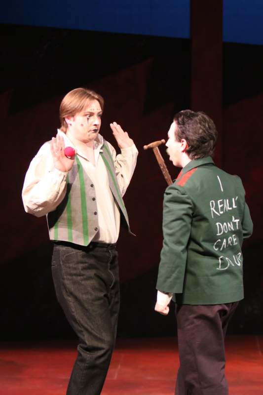 a man holding a stick and a man holding a red object