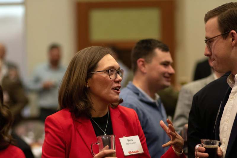 a woman in a red jacket talking to a group of people