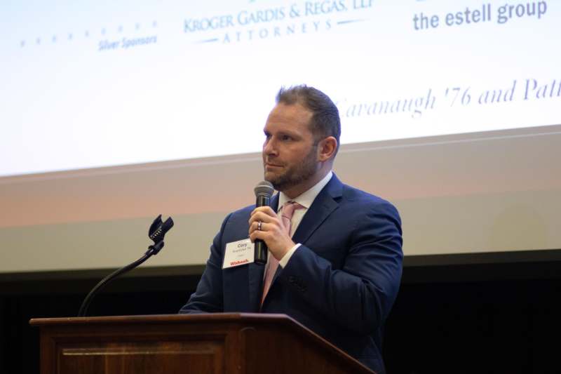 a man in a suit speaking into a microphone