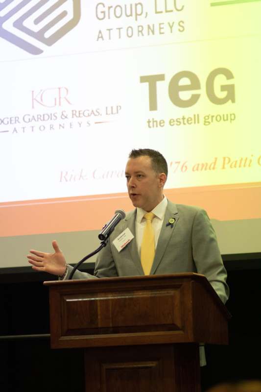 a man standing at a podium with a microphone