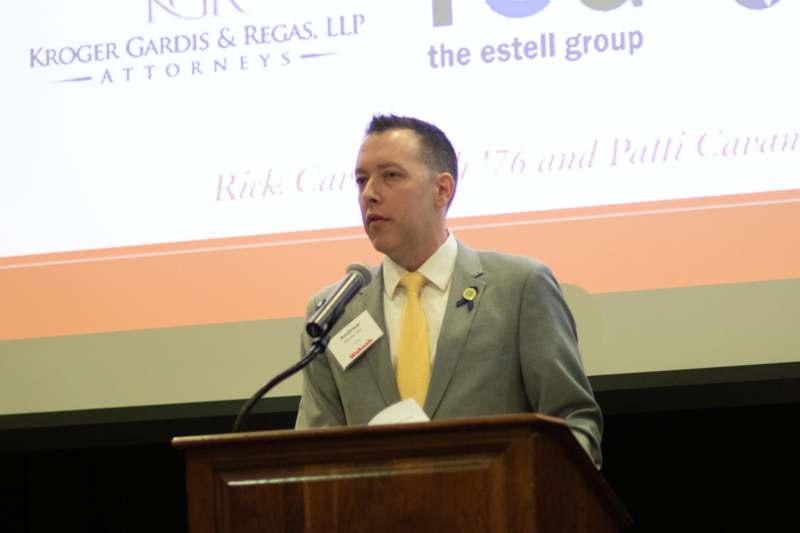 a man standing at a podium with a microphone