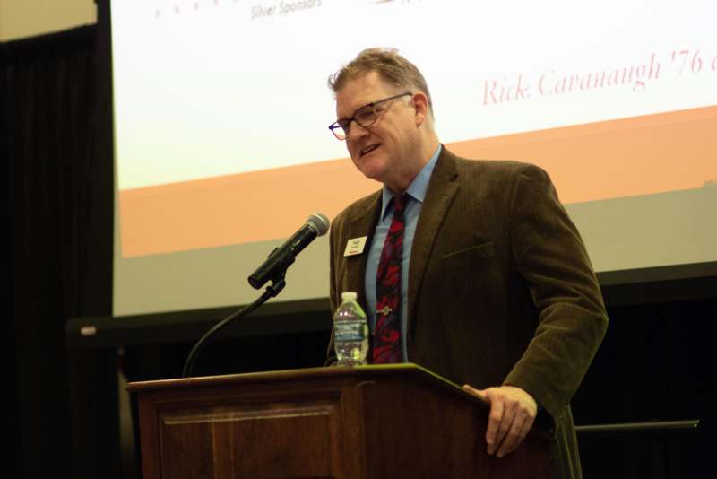 a man standing at a podium with a microphone