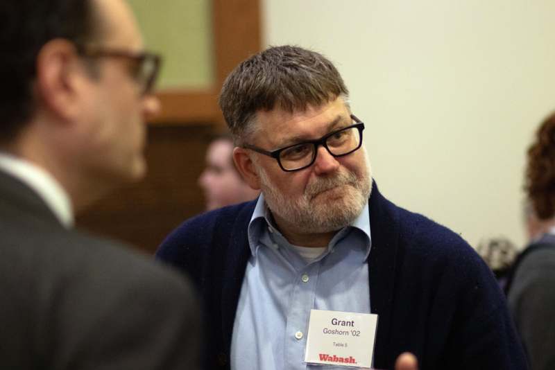 a man wearing glasses and a cardigan