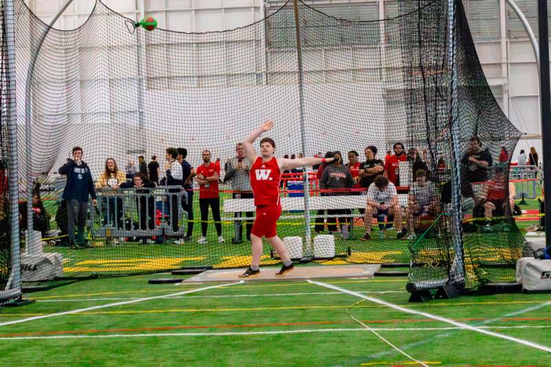 a man throwing a ball in a competition