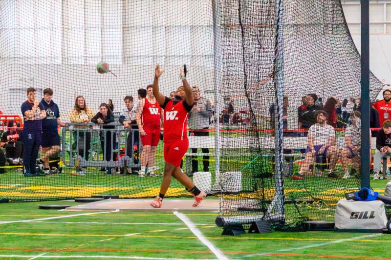 a person in a red uniform throwing a ball