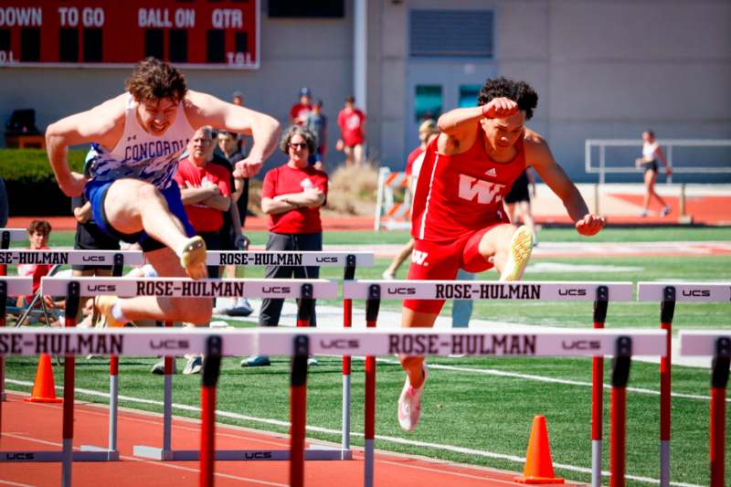a group of people jumping over hurdles