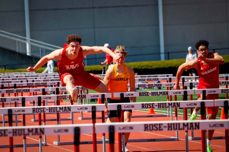 a group of people jumping over hurdles