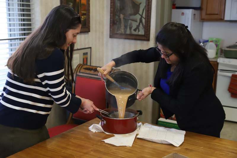 Asian Studies Tea - two women pouring liquid into a pot