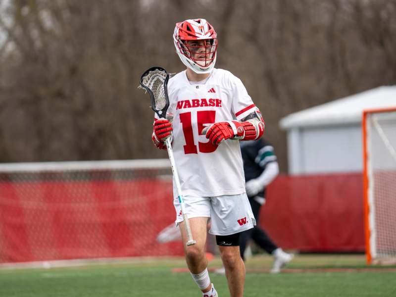 a man wearing a lacrosse uniform and holding a stick