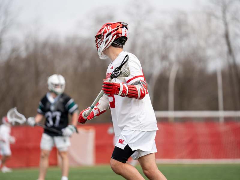 a man wearing a helmet and holding a lacrosse stick