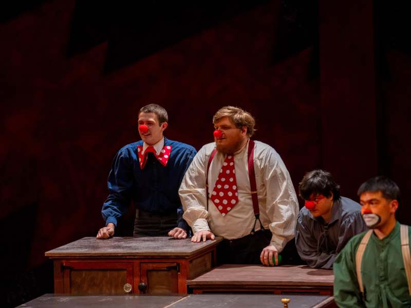 a group of men with red clown nose on a stage